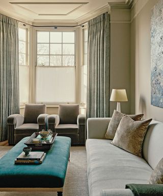 living room with cream sofa and chairs and green ottoman