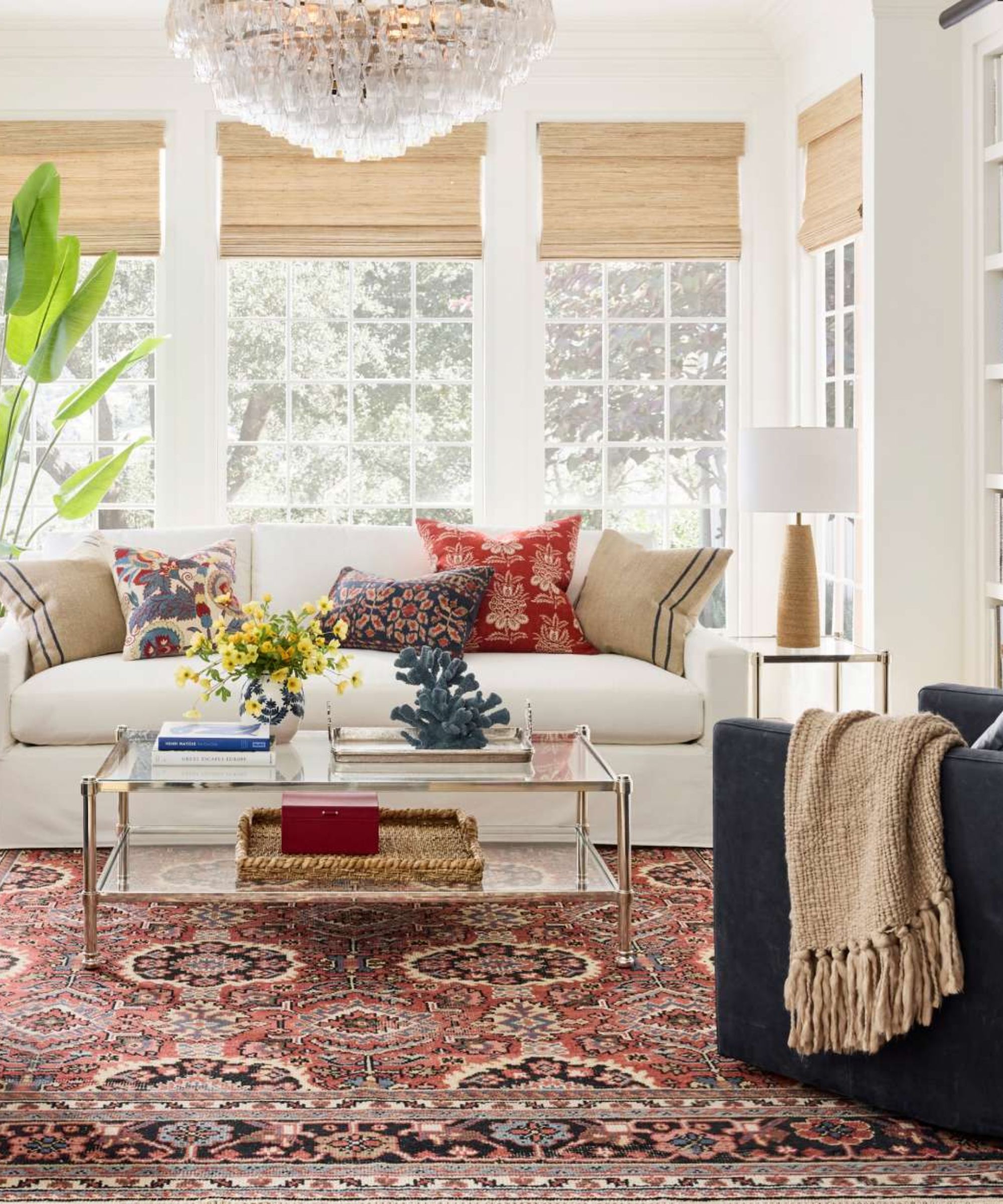 pottery barn white living room with white traditional couch, vintage style rug and a navy armchair