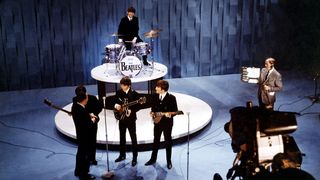 Elevated view of American television personality Ed Sullivan, with the members of the Beatles, during an episode of 'The Ed Sullivan Show' at CBS's Studio 50, New York, New York, February 9, 1964.