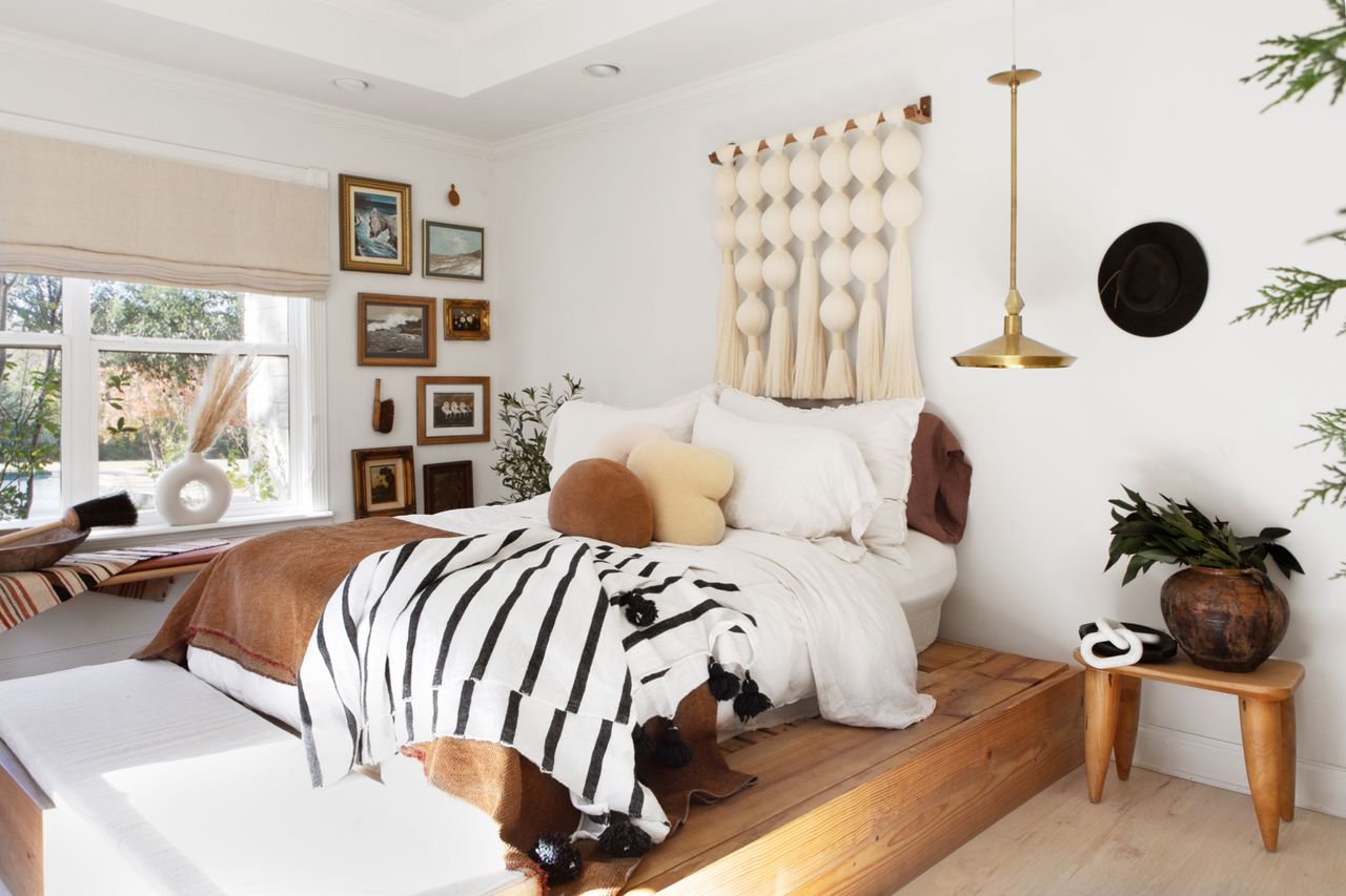 a bedroom with a raised platform bed with stripped and brown bedding