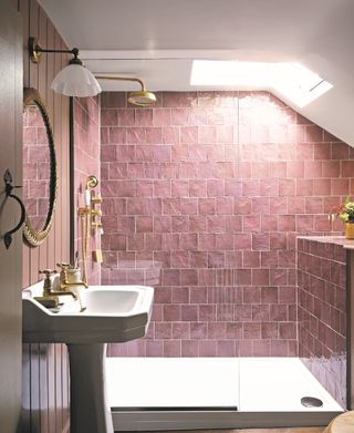bathroom with pink tiles, pink tongue and groove, gold shower, basin and mirror