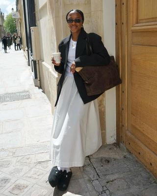 Woman in white skirt and black blazer.