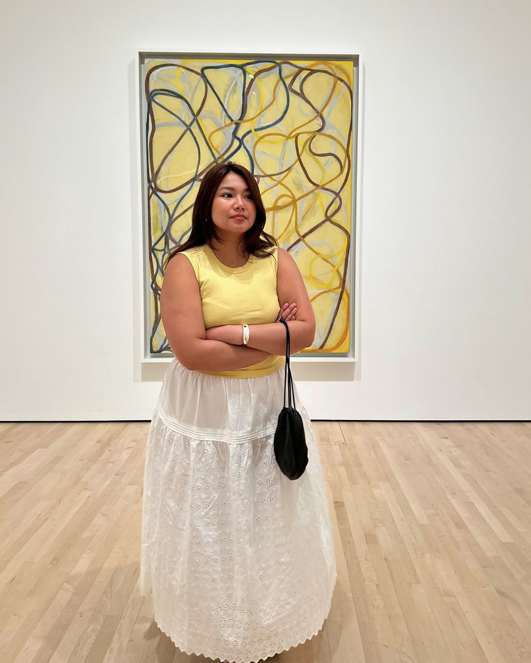@marina_torres wearing a butter yellow top with a white skirt