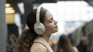 Woman wearing Sony WH-1000Xm4 headphones.