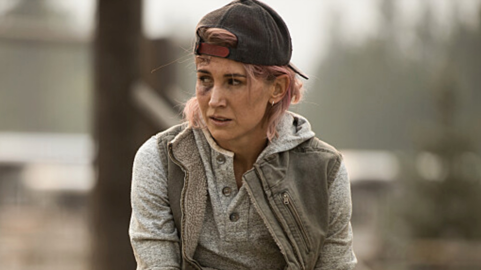 Teeter in backwards cap sitting on fence worriedly in Yellowstone