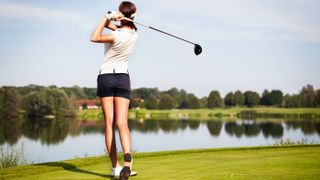 Female golfer teeing off