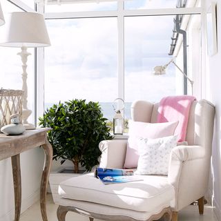 conservatory with armchair with a view and table lamp