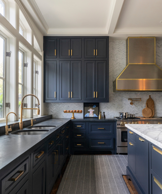 Elegant kitchen with blue painted cabinets, brass hardware and marble island