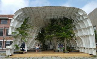 Temp’L by South Korean architectural practice Shinslab. Back view of an artistic structure made from an old ships hull with trees inside of it.