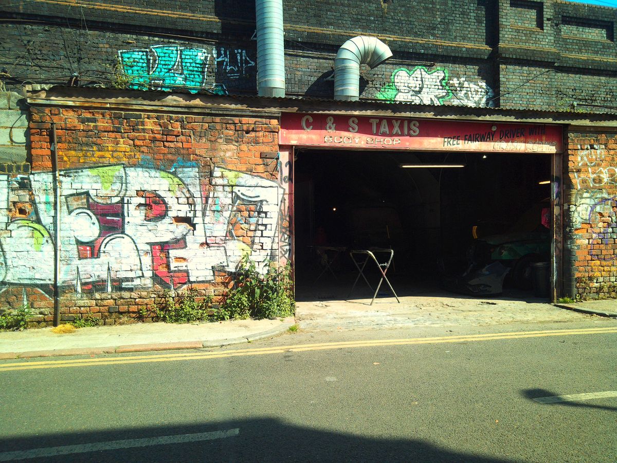 Camp Snap CS-Pro sample image showing garage next to graffiti-covered wall, colors are bright and yellow-toned