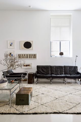 White living room with simple black leather furniture