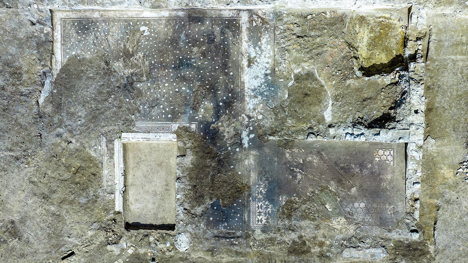archaeologists work at an ancient Roman site revealing mosaic floors and frescoed walls of a villa