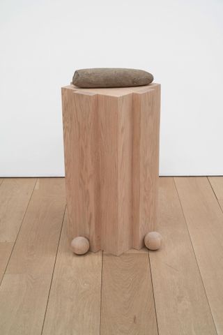 wooden plinth with ancient stone pestle