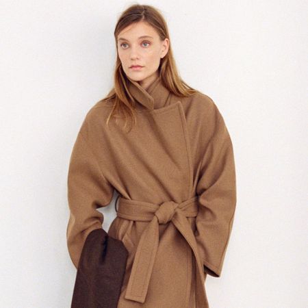 Model wears H&M v-neck white jumper.