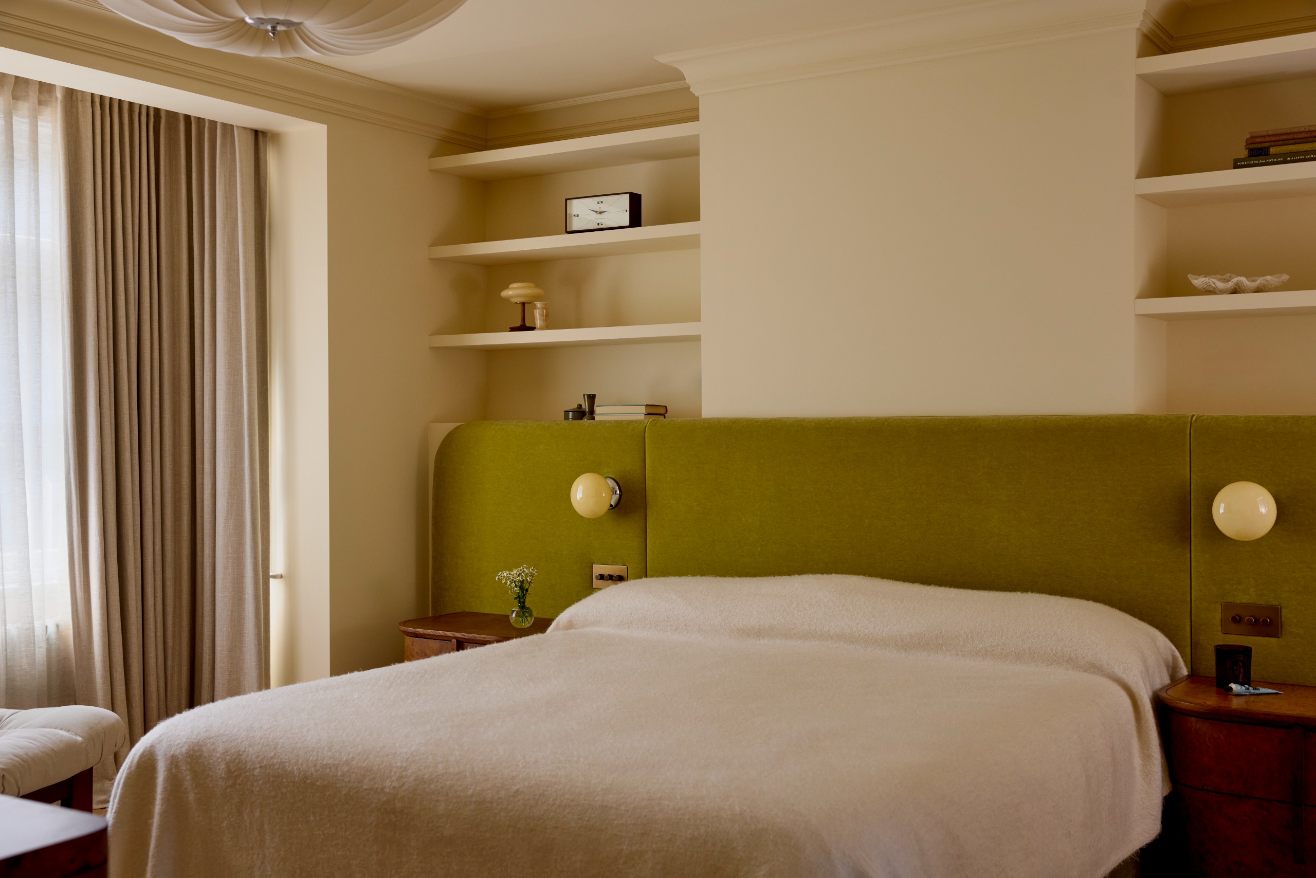 Modern serene bedroom with large bespoke green fabric headboard