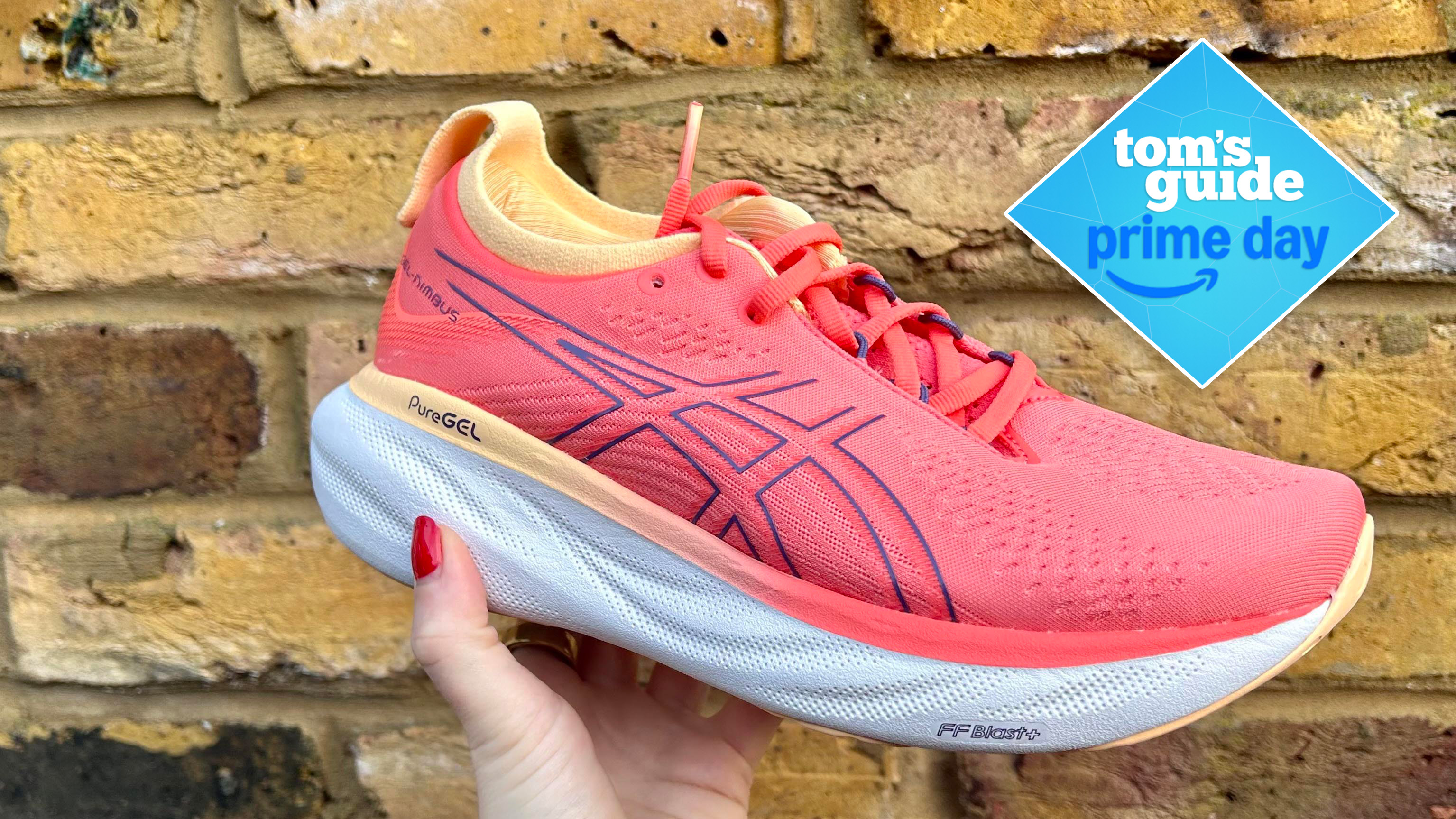 Image of Asics Gel Nimbus 25 in pink against brick wall 