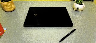 A black ASUS Zenbook Pro 16X OLED laptop on a grey table