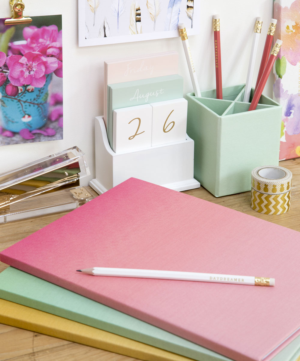 wooden table with journals and pencil holder