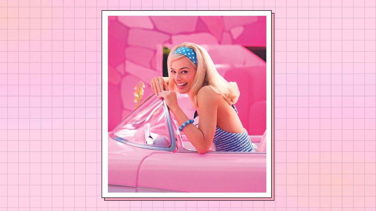 MARGOT ROBBIE as Barbie, sitting in a pink car and wearing a blue top and bracelet with a pink &#039;Barbie&#039; manicure in Warner Bros. Pictures’ “BARBIE&quot; in a pink and orange template