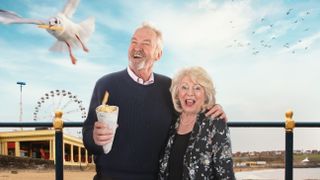Alison Steadman holds a cone of chips as a seagull flies off and Alison Steadman stands next to him against a seaside backgrounds in Alison & Larry: Billericay to Barry.