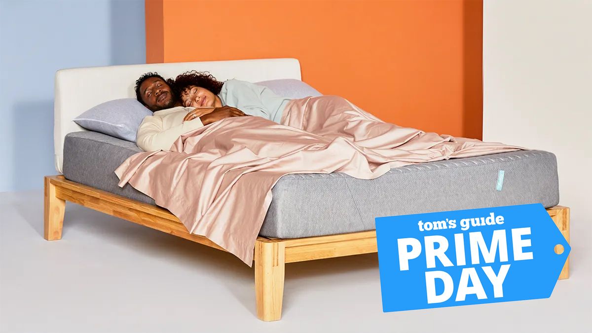 October&#039;s Amazon Prime Day mattress deals guide image shows a couple sleeping on a Siena Memory Foam Mattress placed on a wooden bed frame, with a blue Prime Day sales badge overlaid in the bottom right hand corner