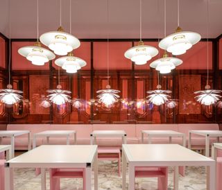 Caffe Taveggia in Milan with pink Louis Poulsen lights and rows of white square tables.