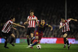 Barcelona midfielder Sergio Busquets on the ball and surrounded by three Athletic Club players in a La Liga game at Camp Nou in February 2011.