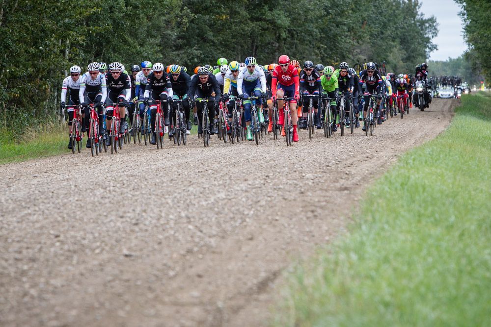 The peloton goes through todays gravel road section