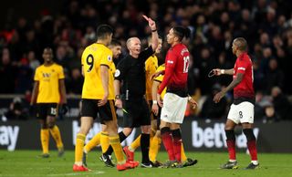 Match referee Mike Dean shows a red card and sends off Manchester United’s Ashley Young