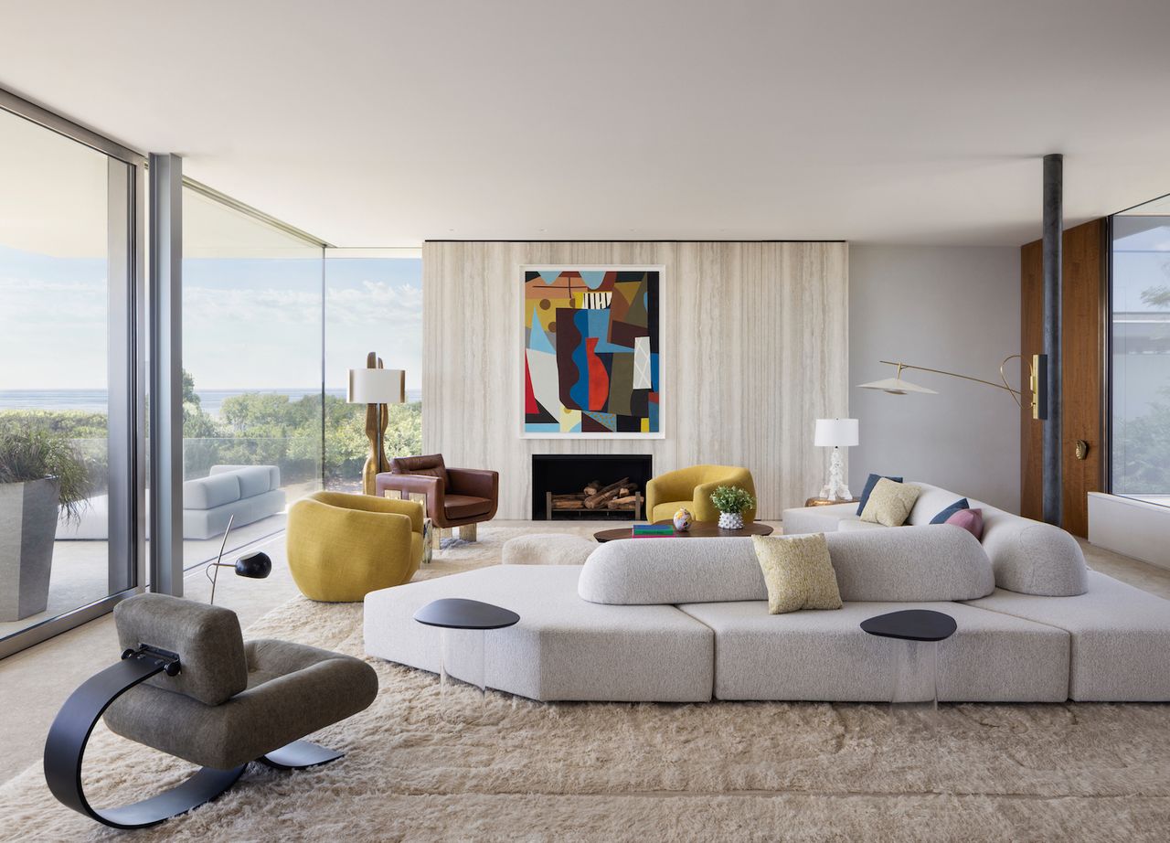 modern living room with long white couch and yellow accent chairs 