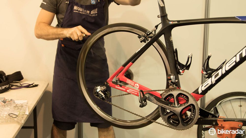 Don't have a truing stand? Just pop the wheel on the outside of the dropout and use something like a ziptie as a gauge. This FDJ mechanic was cleaning the old glue from the rim