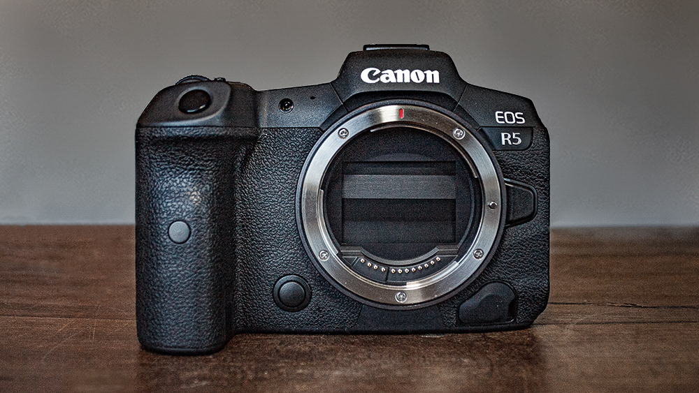 Photograph of Canon EOS R5 mirrorless camera on wooden surface