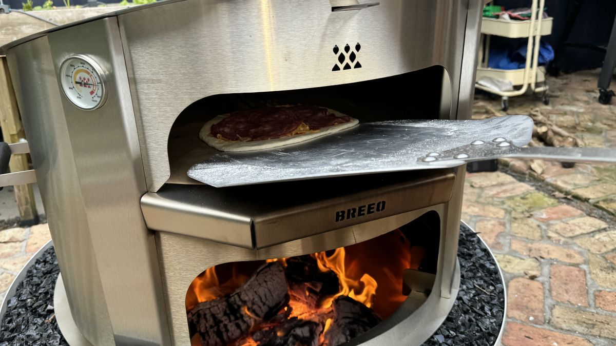 Breeo Live Fire pizza oven with pizza on pizza peel