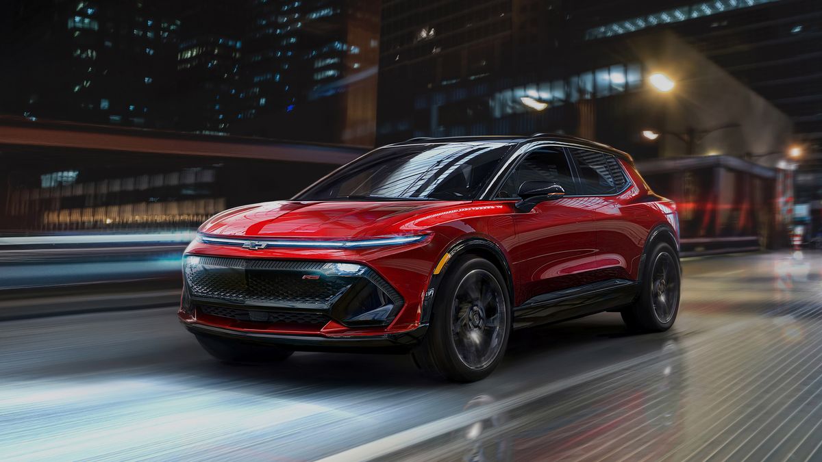 Front view of Equinox EV driving on city street at night