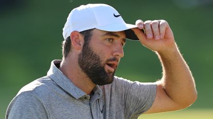 Scottie Scheffler holds the brim of his cap at the 2024 PGA Championship