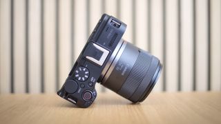 Canon RF 14-30mm f/4-6.3 STM PZ lens, mounted to Canon EOS R50 V, on a wooden surface