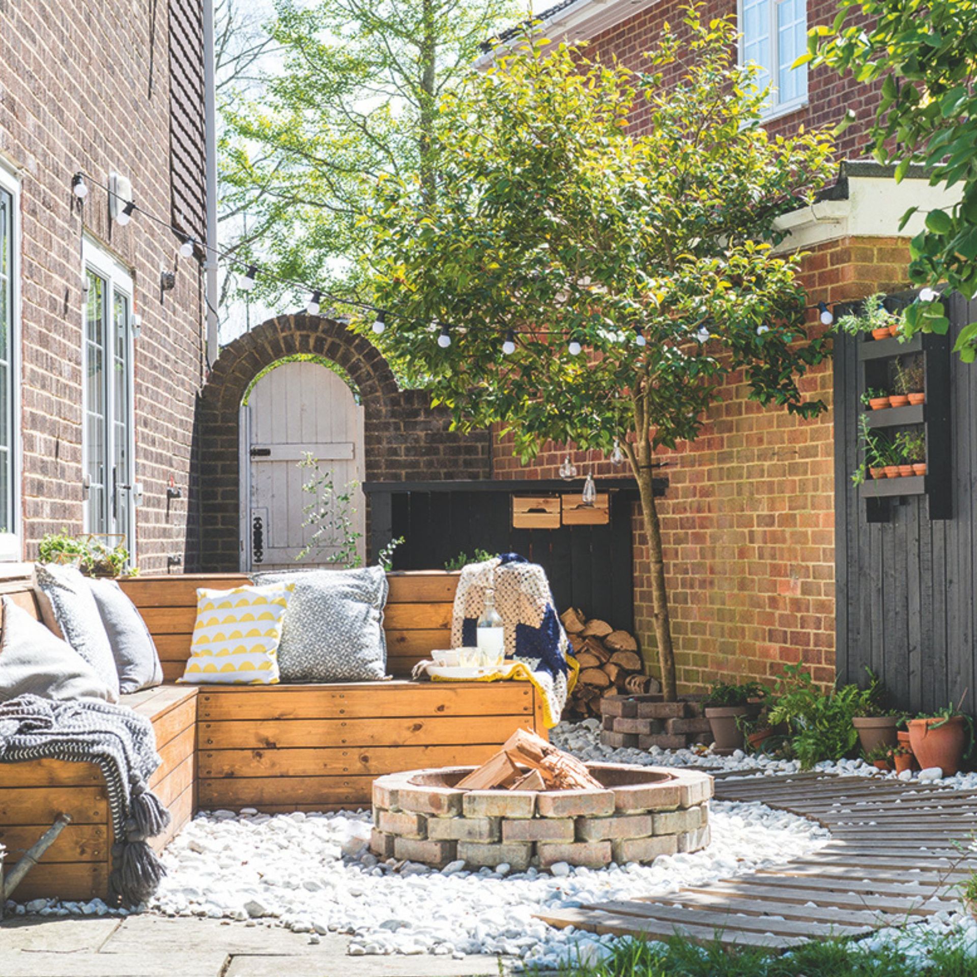 Garden firepit area with pallet furniture and a brick firepit