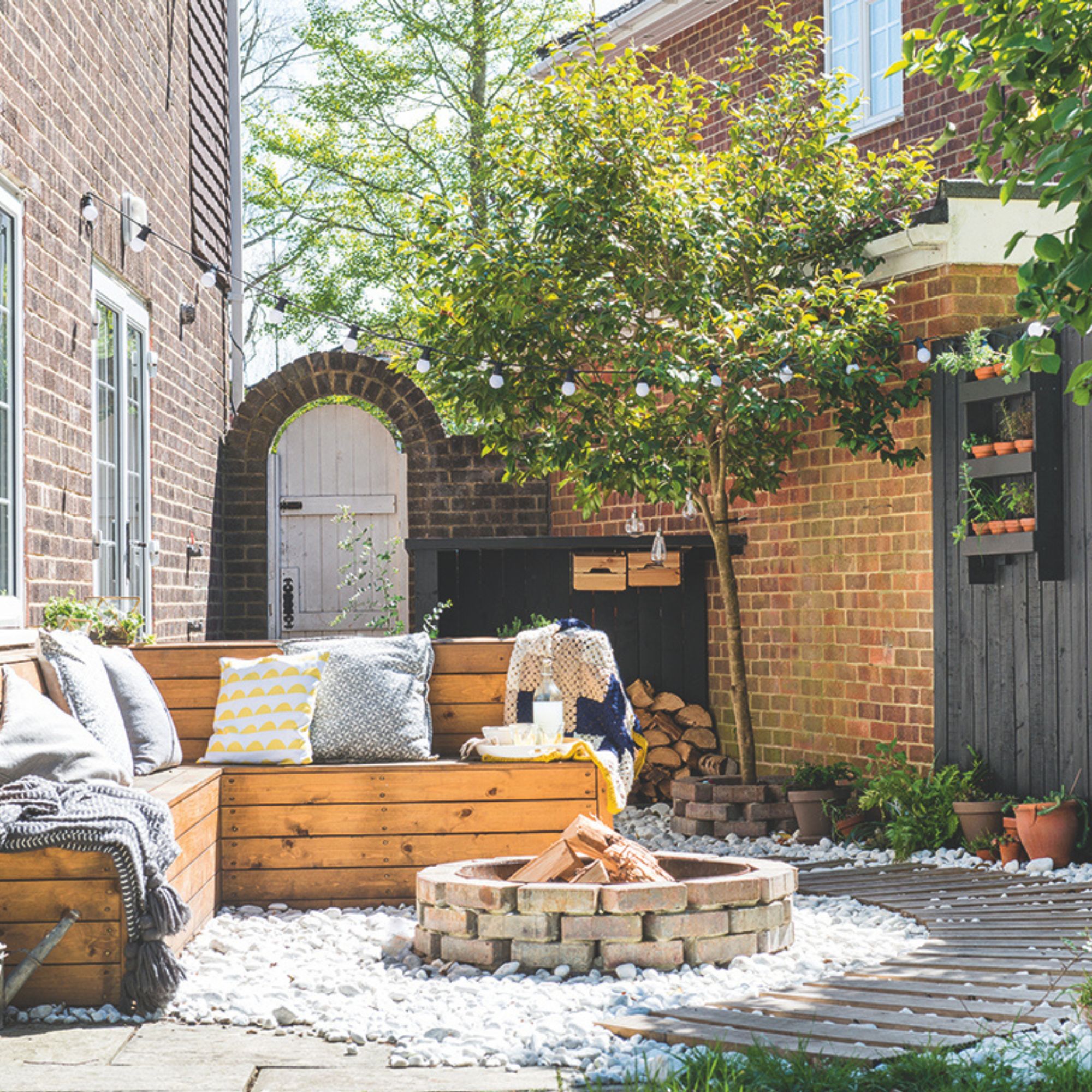 Garden firepit area with pallet furniture and a brick firepit