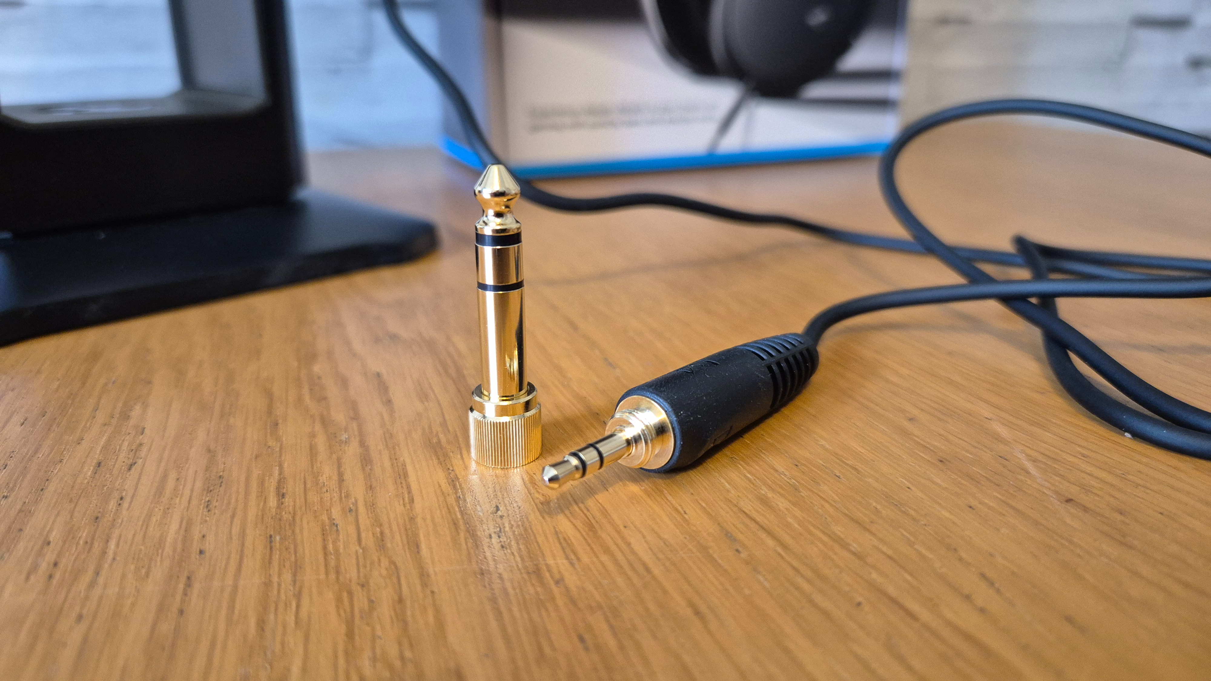 The Sennheiser HD 550 headphones on a wooden surface in front of a white brick background