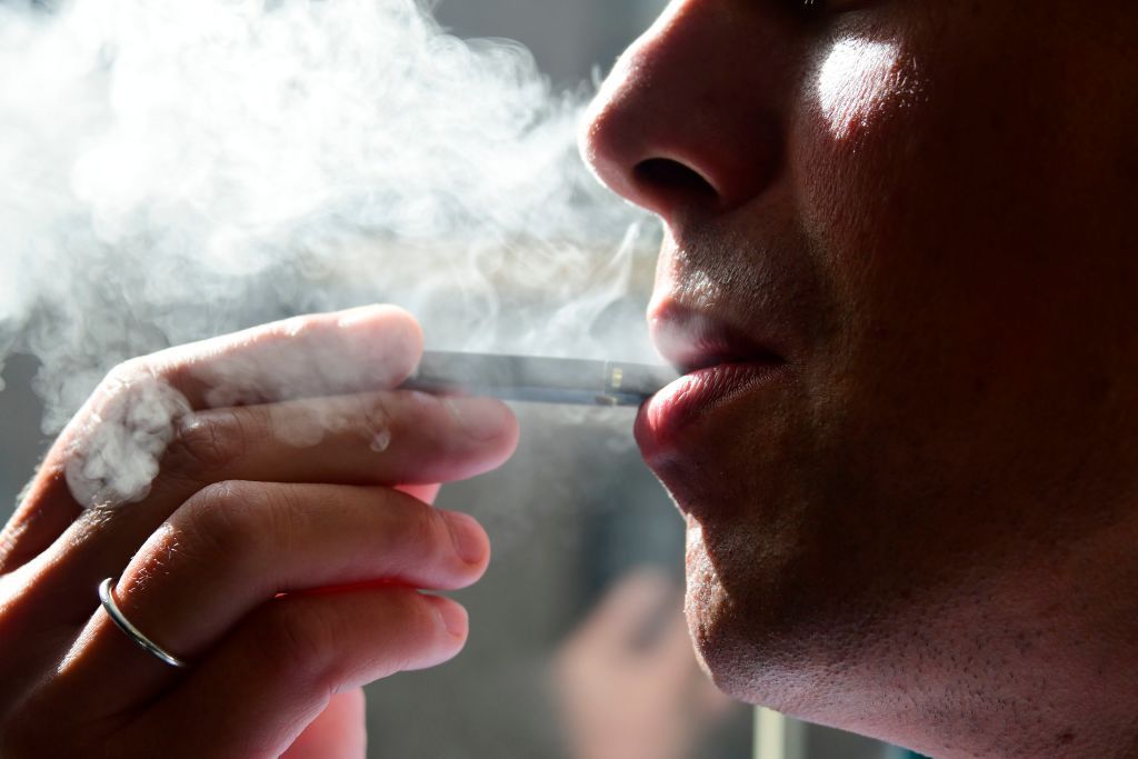 A man smokes an e-cigarette.