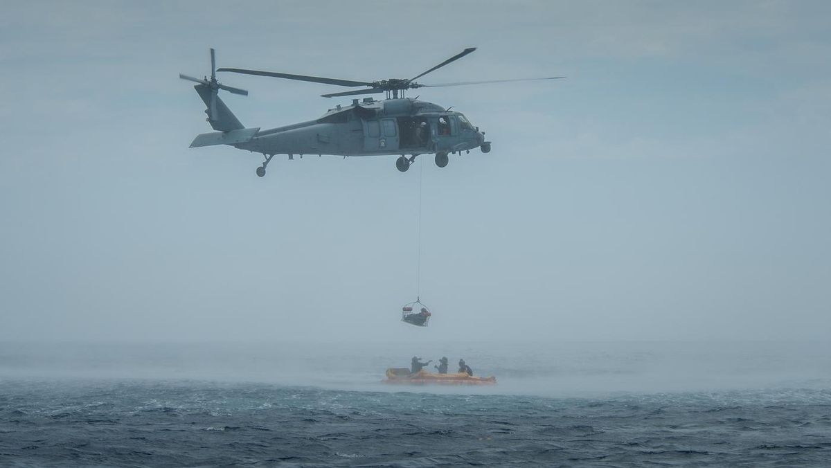 A U.S. Navy helicopter from Helicopter Sea Combat Squadron 23 "Wildcards" practices scooping up people during Artemis 2 recovery exercises on July 29, 2023. NASA, the U.S. Navy and the U.S. Air Force all participated.