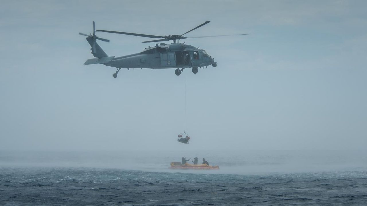 A U.S. Navy helicopter from Helicopter Sea Combat Squadron 23 "Wildcards" practices scooping up people during Artemis 2 recovery exercises on July 29, 2023. NASA, the U.S. Navy and the U.S. Air Force all participated.