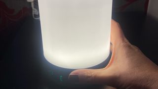 Woman's hand holding Beurer Wake Up Light WL50, emitting white light