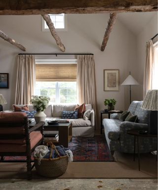 cottage living room with neutral walls, ceiling wooden beams and traditional, cozy furniture