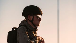 a man wears a commuter helmet at sunset