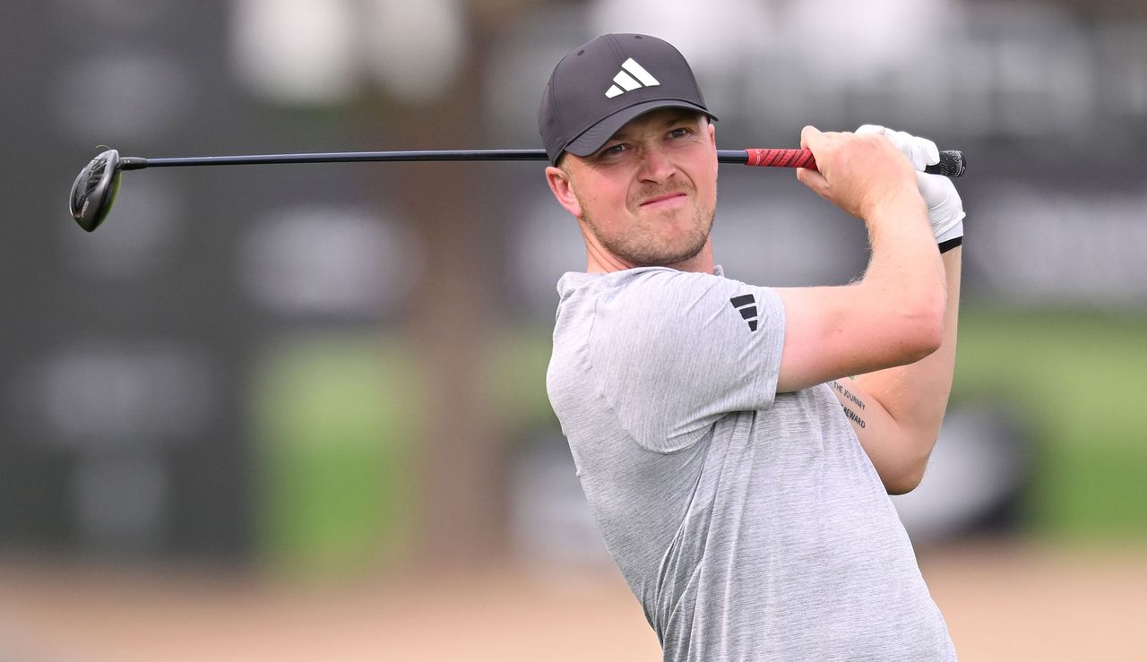 Mansell watches his tee shot after striking his three-wood