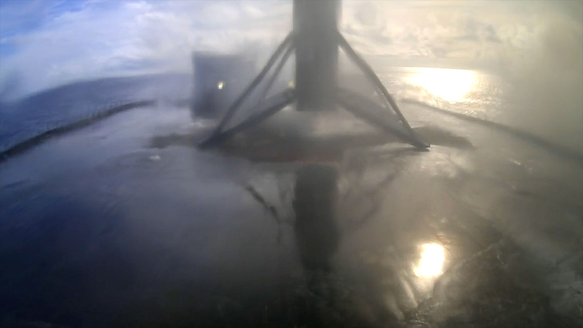 the first stage of a rocket stands on its four deployed legs atop a sea-based droneship  after returning from a launch into space