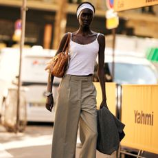 Fashion week attendee wearing trousers, white tank top and white headband