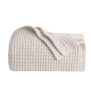 A folded beige waffle throw with the corner folded over