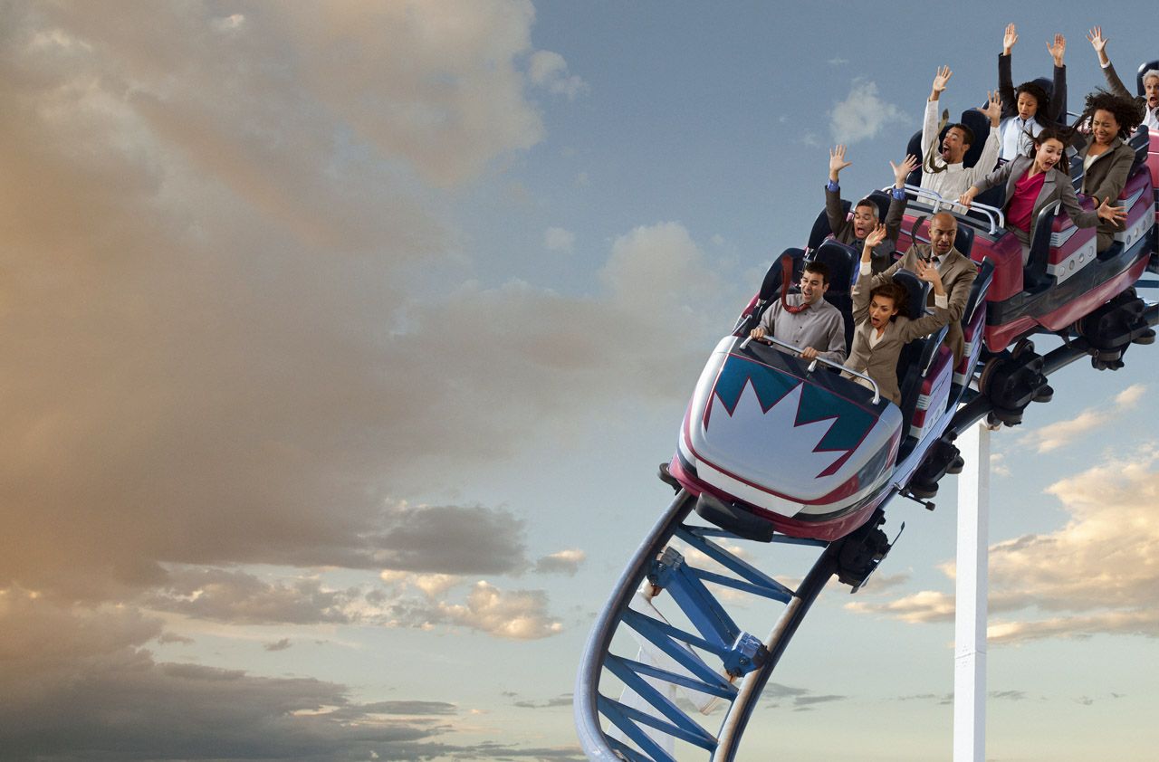 Business people riding roller coaster